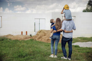 izodom szczesliwa rodzina z dziecmi przed swoim domem