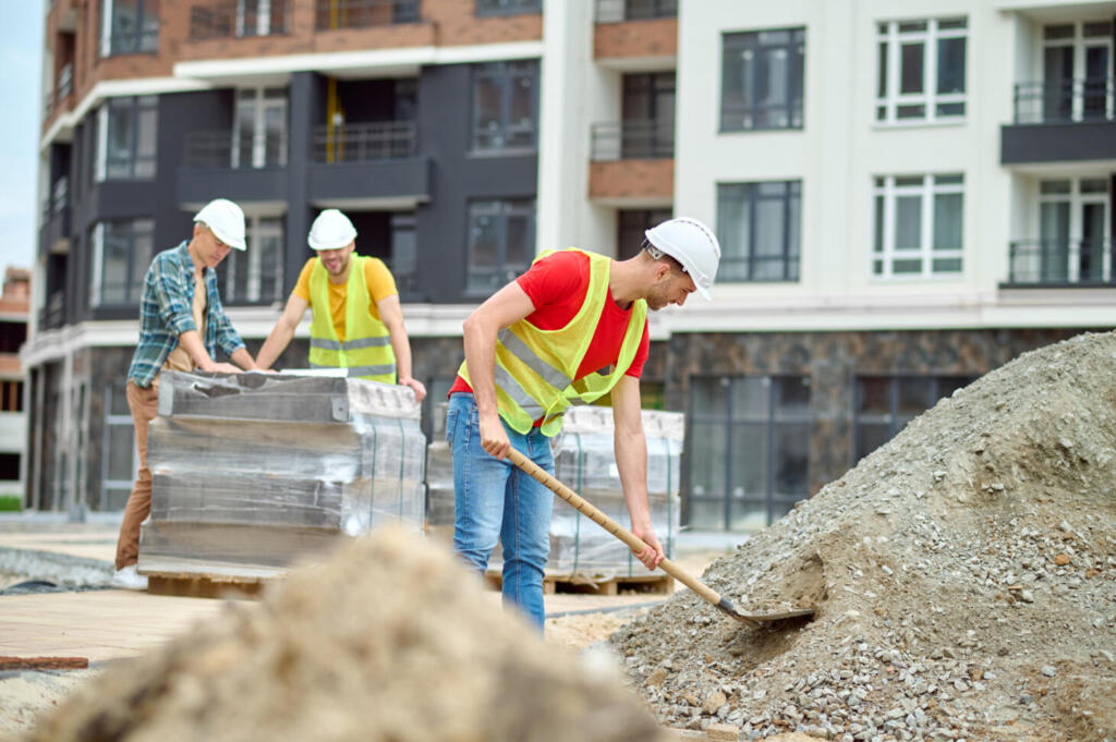 izodom prace na budowie mezczyzni z lopata